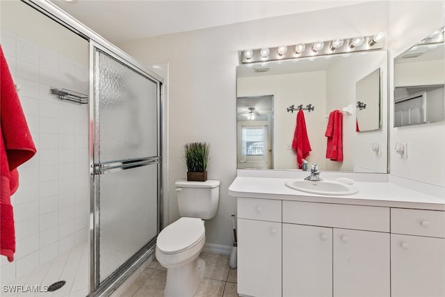 bathroom featuring tile patterned floors, toilet, vanity, and a shower with shower door