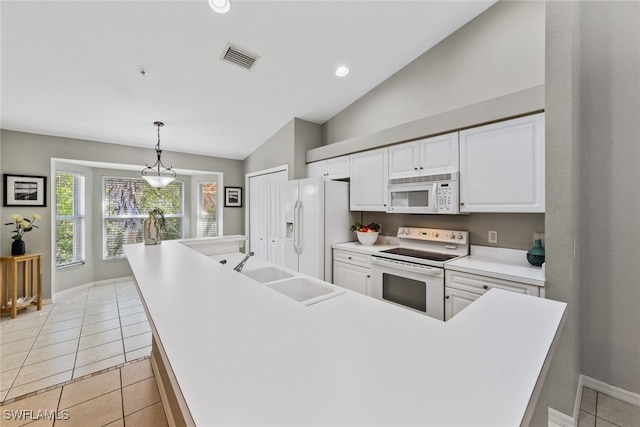 kitchen with white appliances, sink, vaulted ceiling, decorative light fixtures, and light tile patterned floors