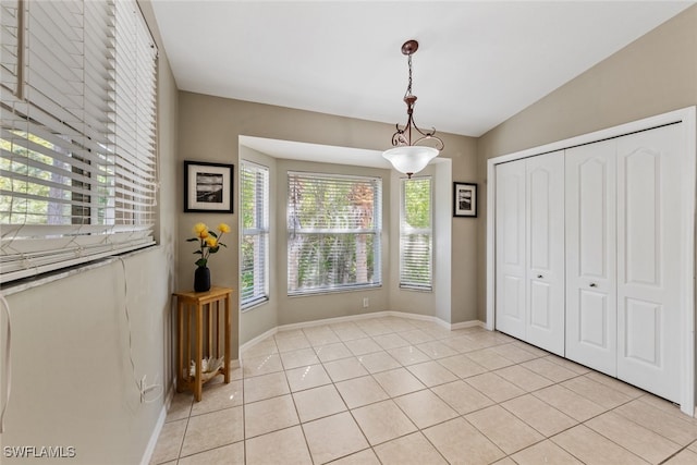 interior space with lofted ceiling and light tile patterned floors