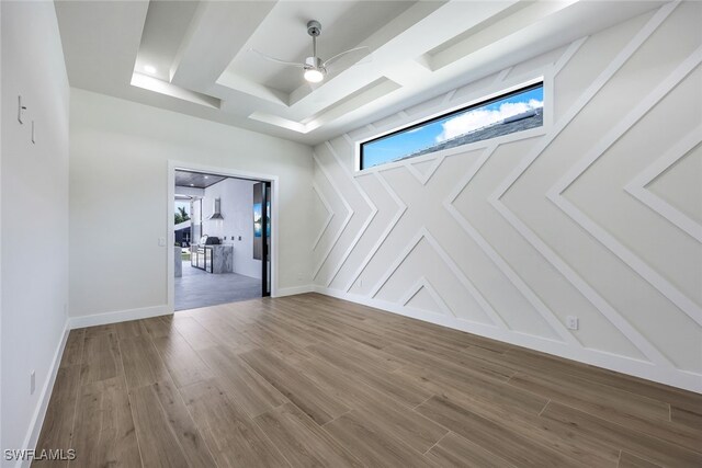 empty room featuring hardwood / wood-style floors, a tray ceiling, and ceiling fan