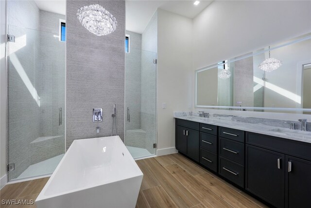 bathroom with vanity, an inviting chandelier, separate shower and tub, and hardwood / wood-style floors