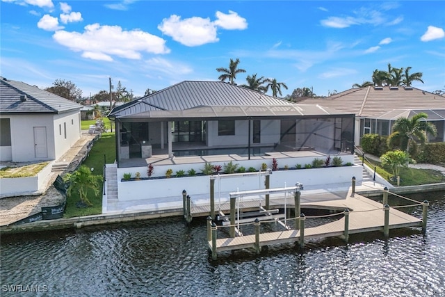 rear view of house featuring boat lift, a water view, a lanai, and a pool