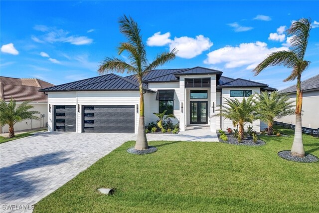 contemporary home with french doors, a garage, and a front lawn