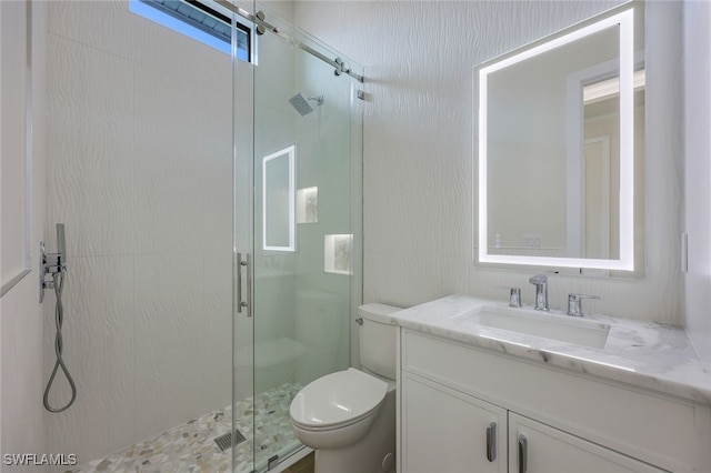 full bathroom with toilet, a stall shower, and vanity