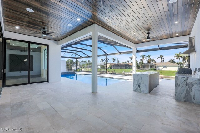 view of swimming pool with ceiling fan, a lanai, and a patio area