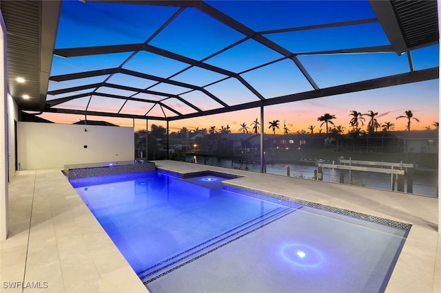 outdoor pool featuring a lanai, a water view, and a patio area