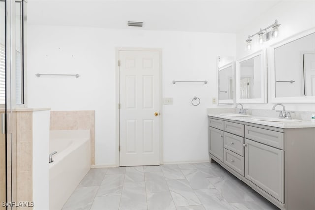 bathroom with a tub and vanity