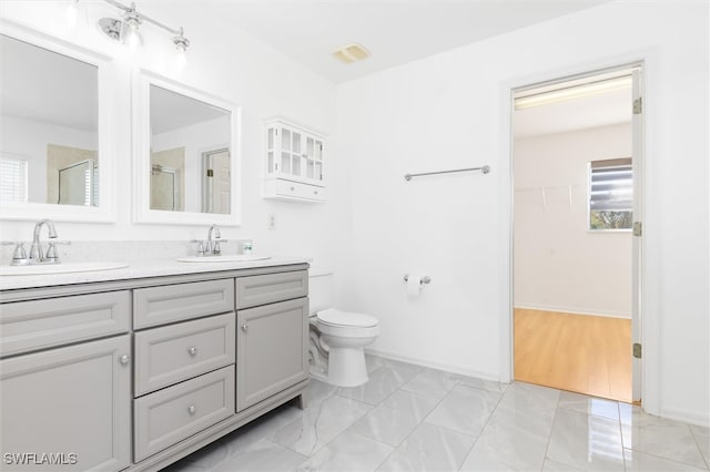 bathroom featuring an enclosed shower, vanity, and toilet