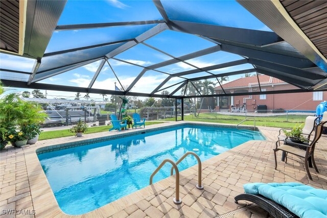 view of swimming pool featuring a patio area and a lanai