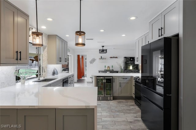 kitchen with gray cabinetry, sink, beverage cooler, kitchen peninsula, and black appliances