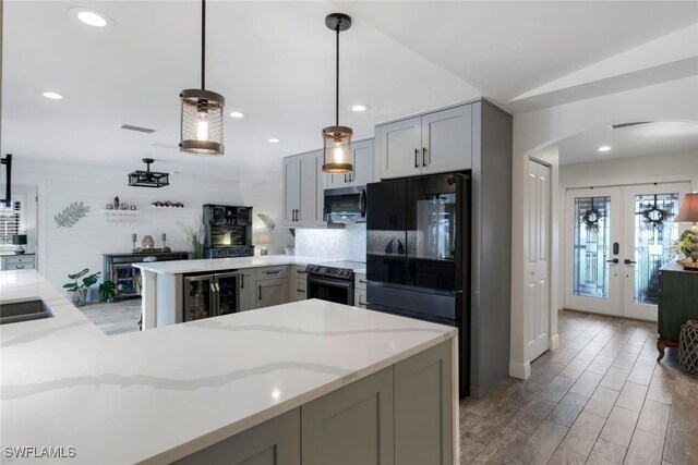 kitchen with kitchen peninsula, gray cabinetry, french doors, and stainless steel appliances