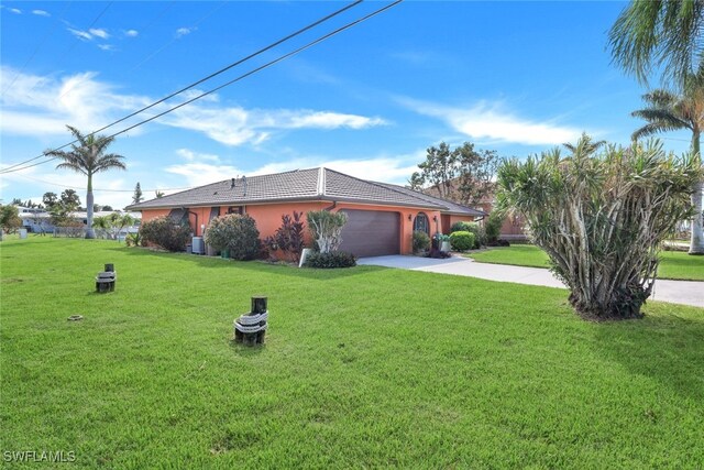 view of front facade with a garage, a front yard, and central AC