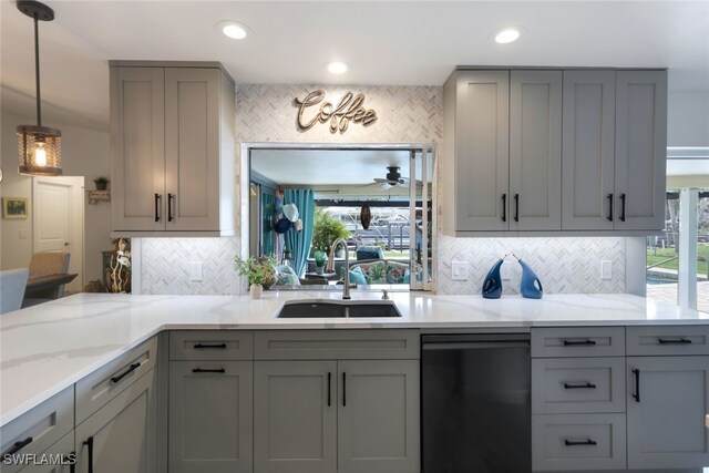 kitchen featuring backsplash, decorative light fixtures, gray cabinets, and sink