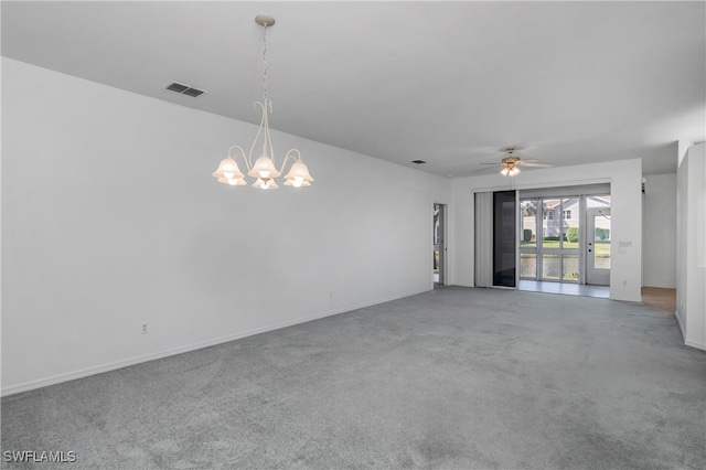 carpeted spare room featuring ceiling fan with notable chandelier