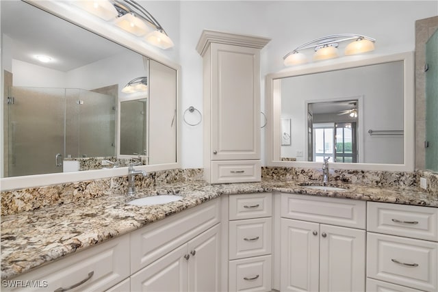 bathroom with a shower with door, vanity, and ceiling fan