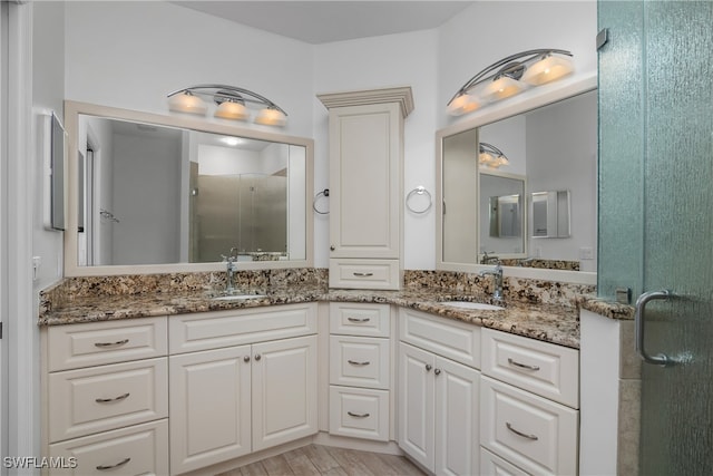 bathroom with vanity, a shower with shower door, and wood-type flooring