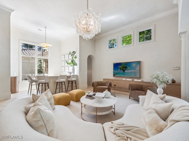 living room featuring crown molding, a towering ceiling, and a chandelier