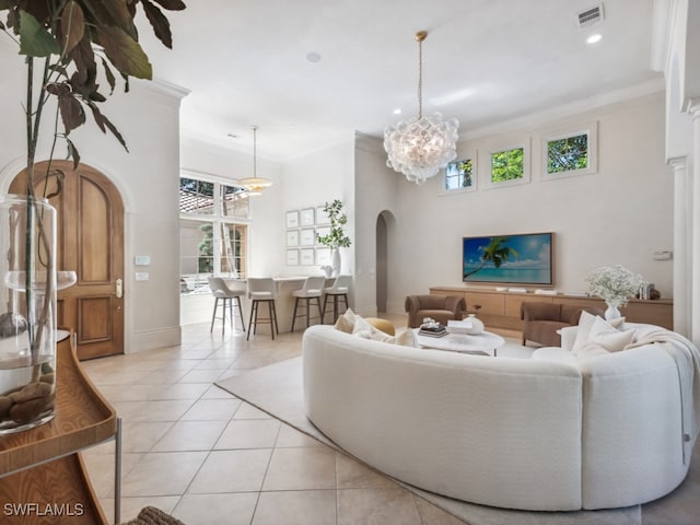 tiled living room with a towering ceiling, a notable chandelier, and crown molding