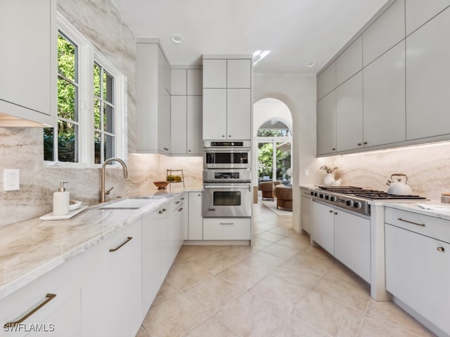 kitchen featuring appliances with stainless steel finishes, sink, decorative backsplash, and white cabinets