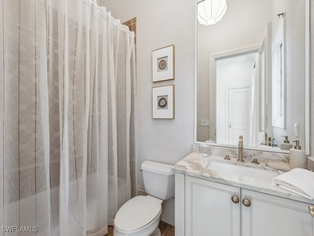 bathroom with toilet, vanity, and a shower with shower curtain