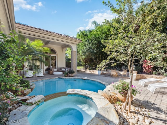 view of swimming pool featuring a patio and an in ground hot tub