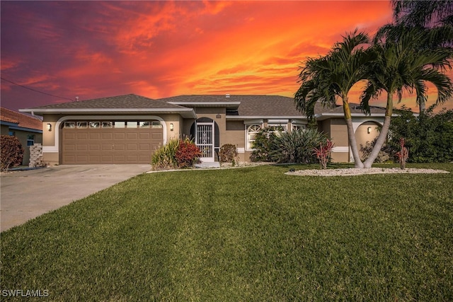 view of front of house with a garage and a yard