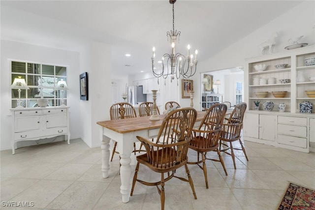 dining room with vaulted ceiling, a notable chandelier, and light tile patterned floors