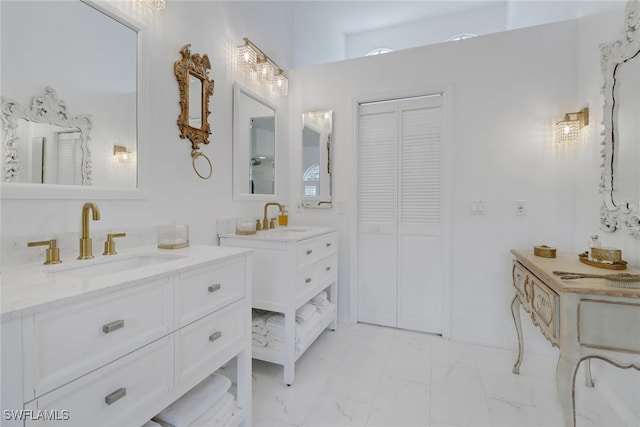 full bath with marble finish floor, two vanities, and a sink