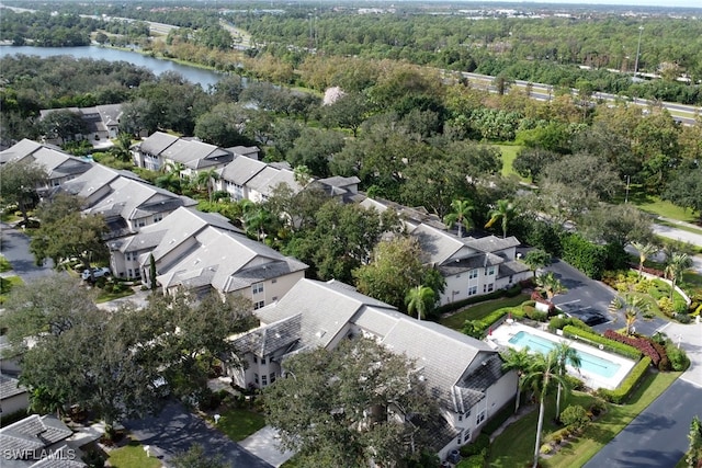 drone / aerial view with a water view, a residential view, and a wooded view