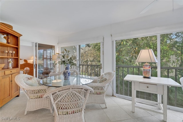 sunroom / solarium with tile patterned floors and outdoor dining area