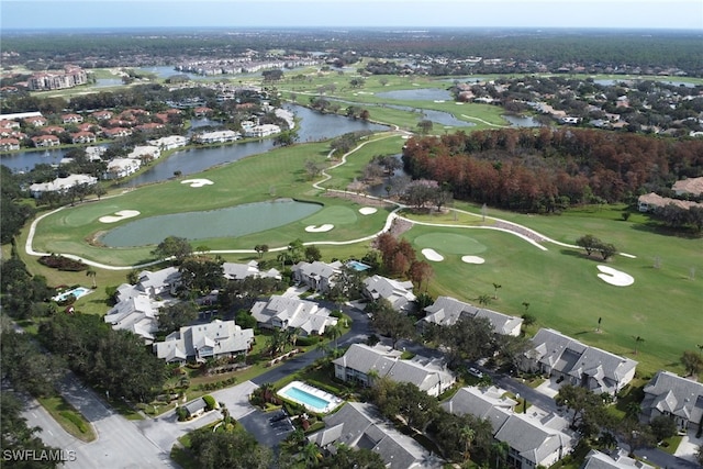 drone / aerial view with view of golf course, a residential view, and a water view