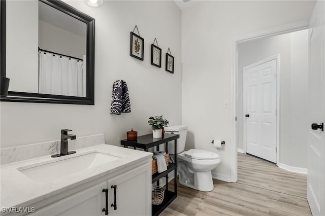 bathroom with vanity, toilet, and wood-type flooring