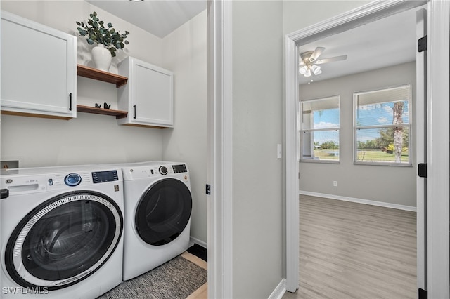 clothes washing area featuring ceiling fan, light hardwood / wood-style flooring, cabinets, and washer and clothes dryer