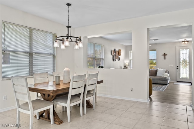 dining room with light hardwood / wood-style floors and an inviting chandelier