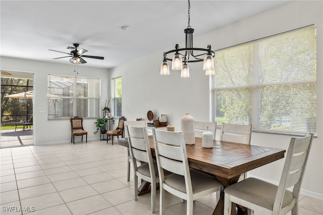 tiled dining area with a wealth of natural light and ceiling fan with notable chandelier