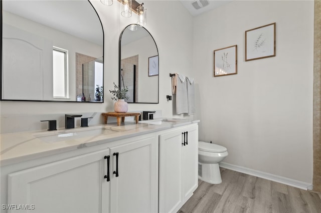 bathroom with vanity, toilet, a shower, and hardwood / wood-style floors