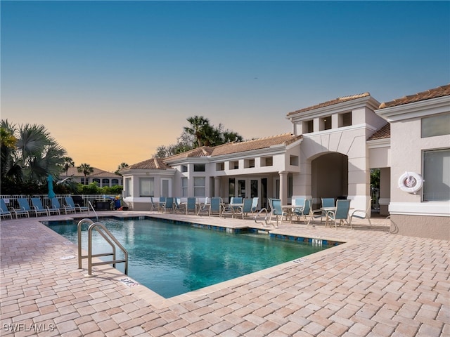 pool at dusk with a patio