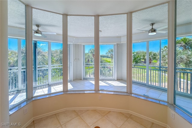 unfurnished sunroom with ceiling fan and a healthy amount of sunlight