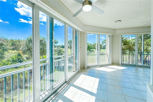 unfurnished sunroom with ceiling fan