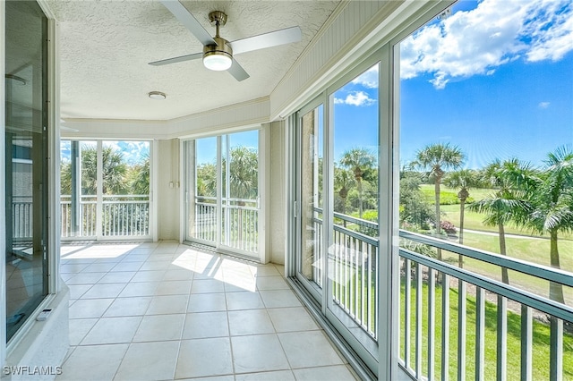 unfurnished sunroom featuring ceiling fan