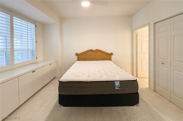 carpeted bedroom with ceiling fan and a closet