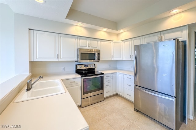 kitchen featuring stainless steel appliances, white cabinetry, sink, and light tile patterned floors