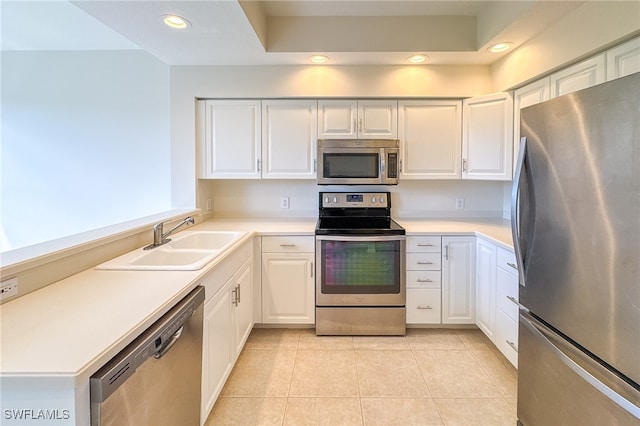 kitchen with white cabinets, sink, light tile patterned floors, and stainless steel appliances