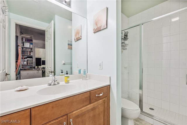 bathroom featuring vanity, toilet, and a shower with shower door