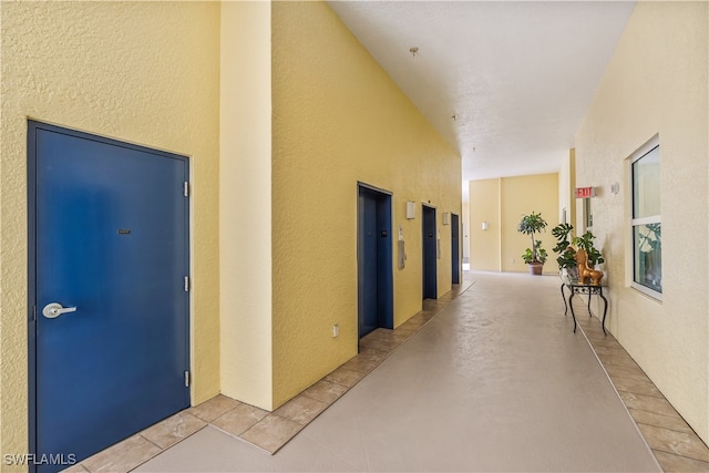 corridor with light tile patterned floors and elevator