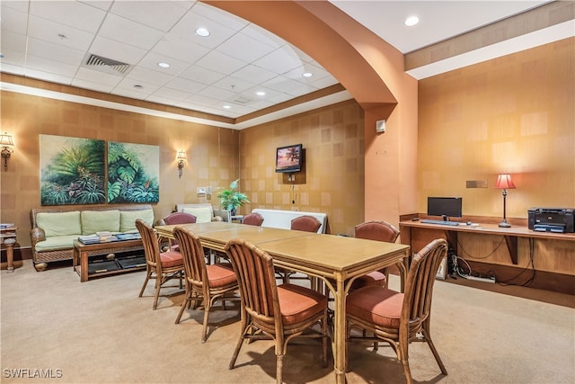 carpeted dining area with a paneled ceiling