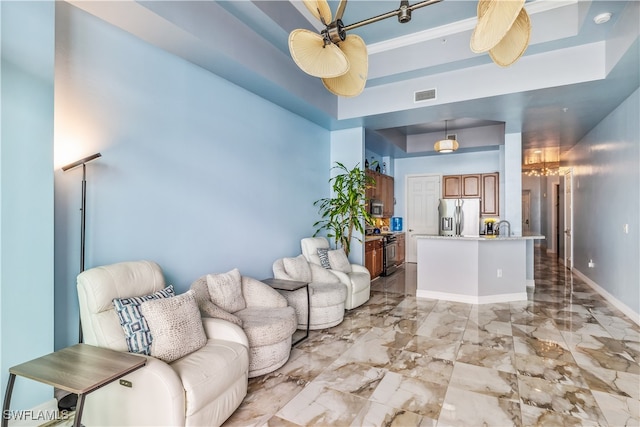 living room with a tray ceiling and ceiling fan