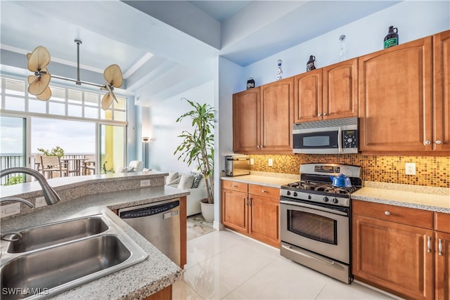 kitchen with sink, decorative backsplash, stainless steel appliances, and light tile patterned floors