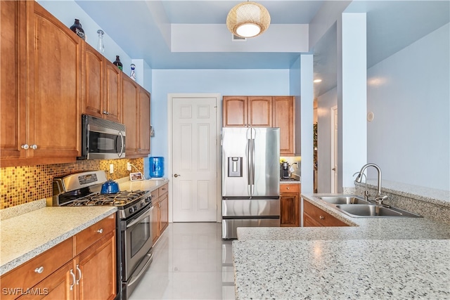 kitchen featuring light stone counters, light tile patterned floors, backsplash, sink, and stainless steel appliances