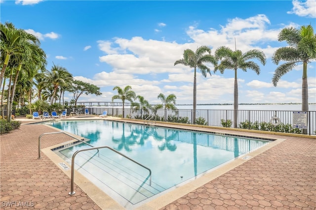 view of swimming pool with a patio and a water view